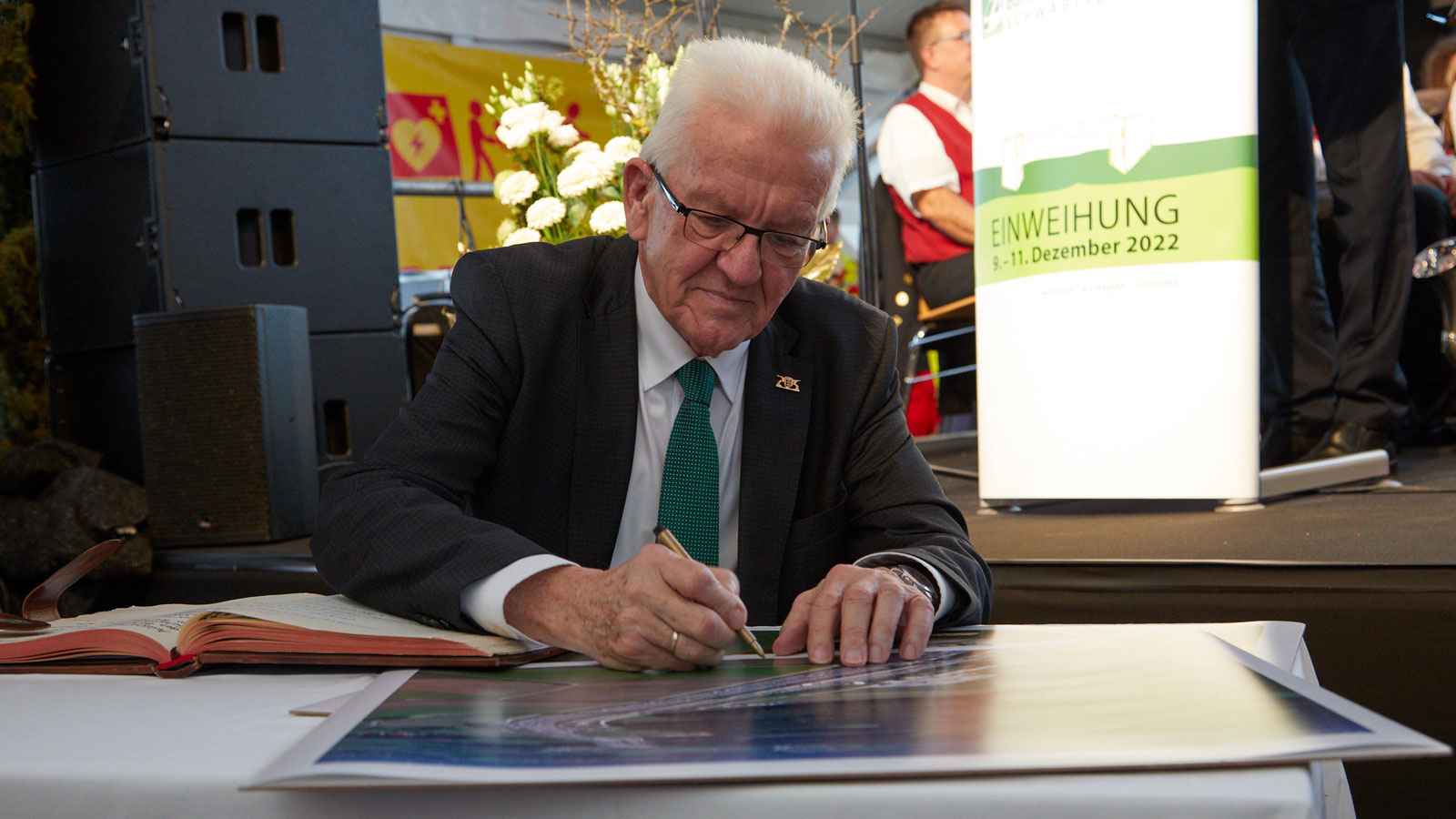 Ministerpräsident Winfried Kretschmann zeichnet in ein Übersichtsbild des Bahnhofs Merklingen